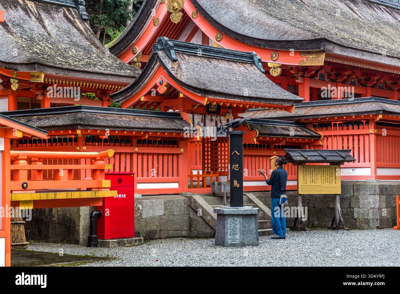 Kumano Nachi Taisha is one of the three major shrines (Kumano Sanzan) in the Kumano region. It is a central pilgrimage site on the Kumano Kodo trail. A man prays in front of the shrine in Nachikatsuura, Wakayama Prefecture, Japan. Stock Photo