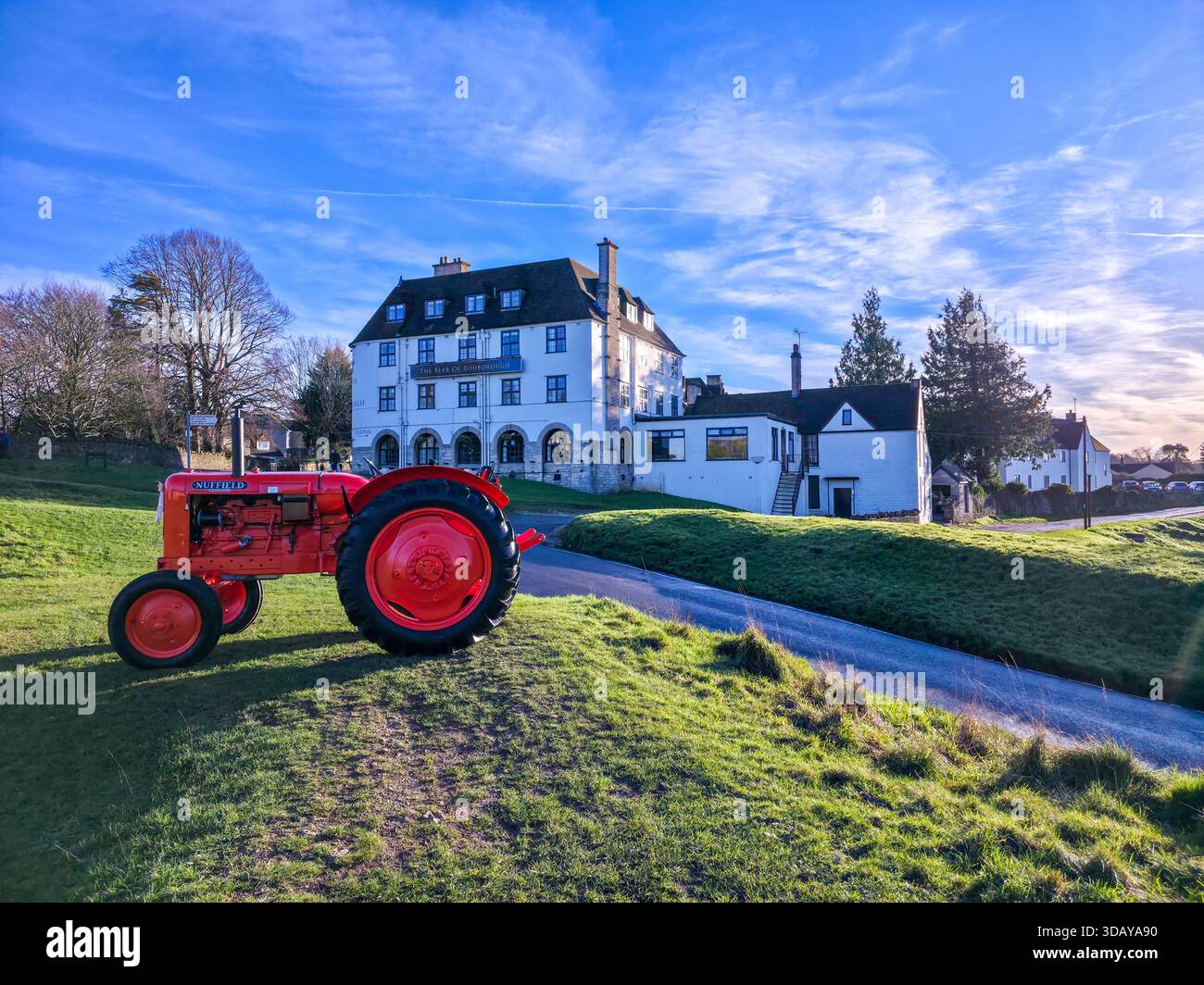 Red Vintage Tractor at Golden Hour in Front of Cotswolds Manor House - Smartphone Captured Stock Image