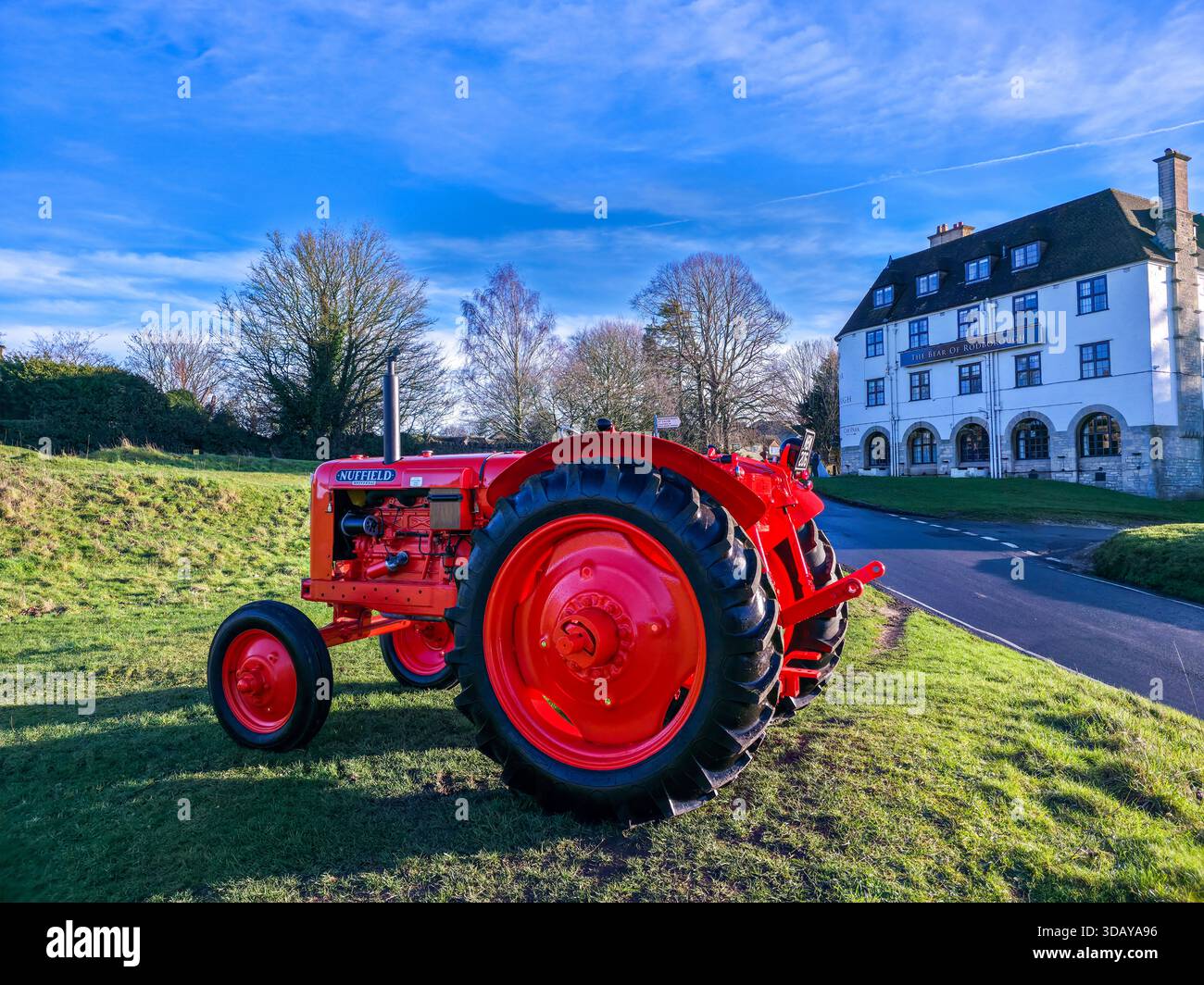 Bright Red Vintage Tractor Parked in Front of Cotswolds Manor House - Smartphone Captured Stock Image