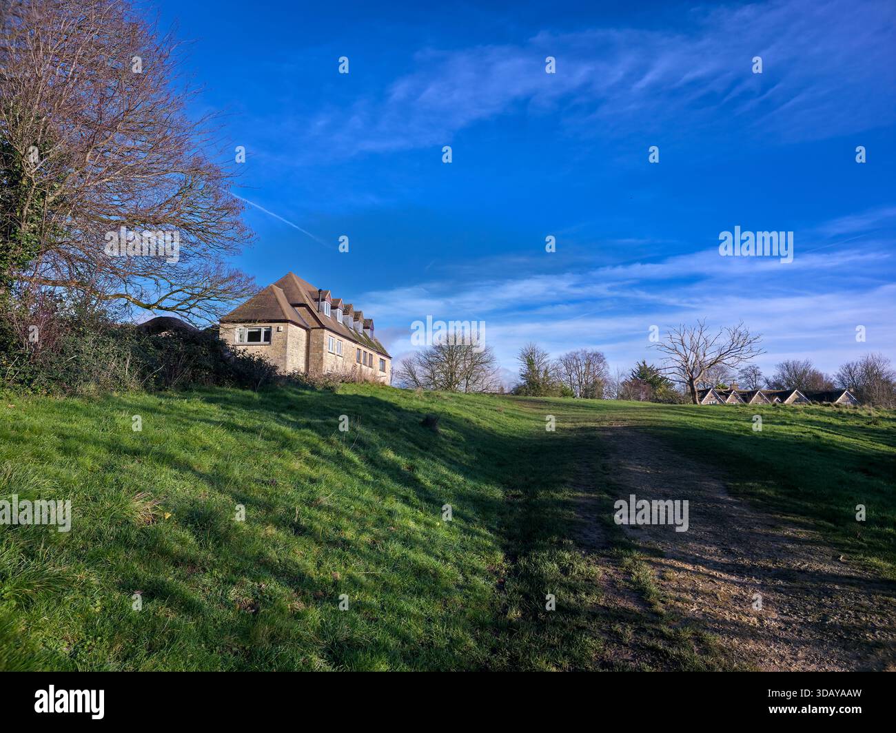 Traditional Cotswolds Stone House on Grassy Hill with Rural Path - Smartphone Captured Stock Image