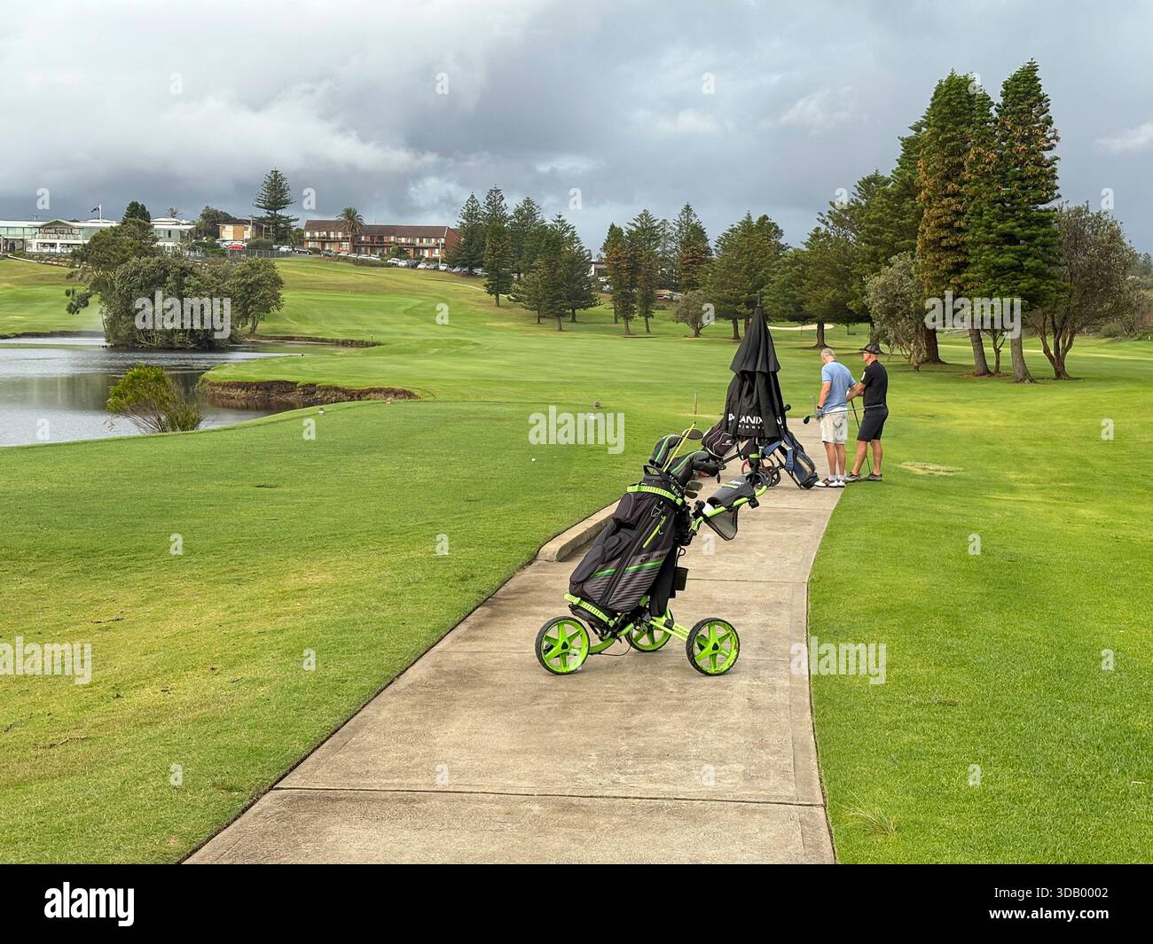Play Golf Australia, two male golfers with their golf club bags and push buggies on Mona Vale golf course,Sydney,NSW,Australia - Smartphone Captured Stock Image