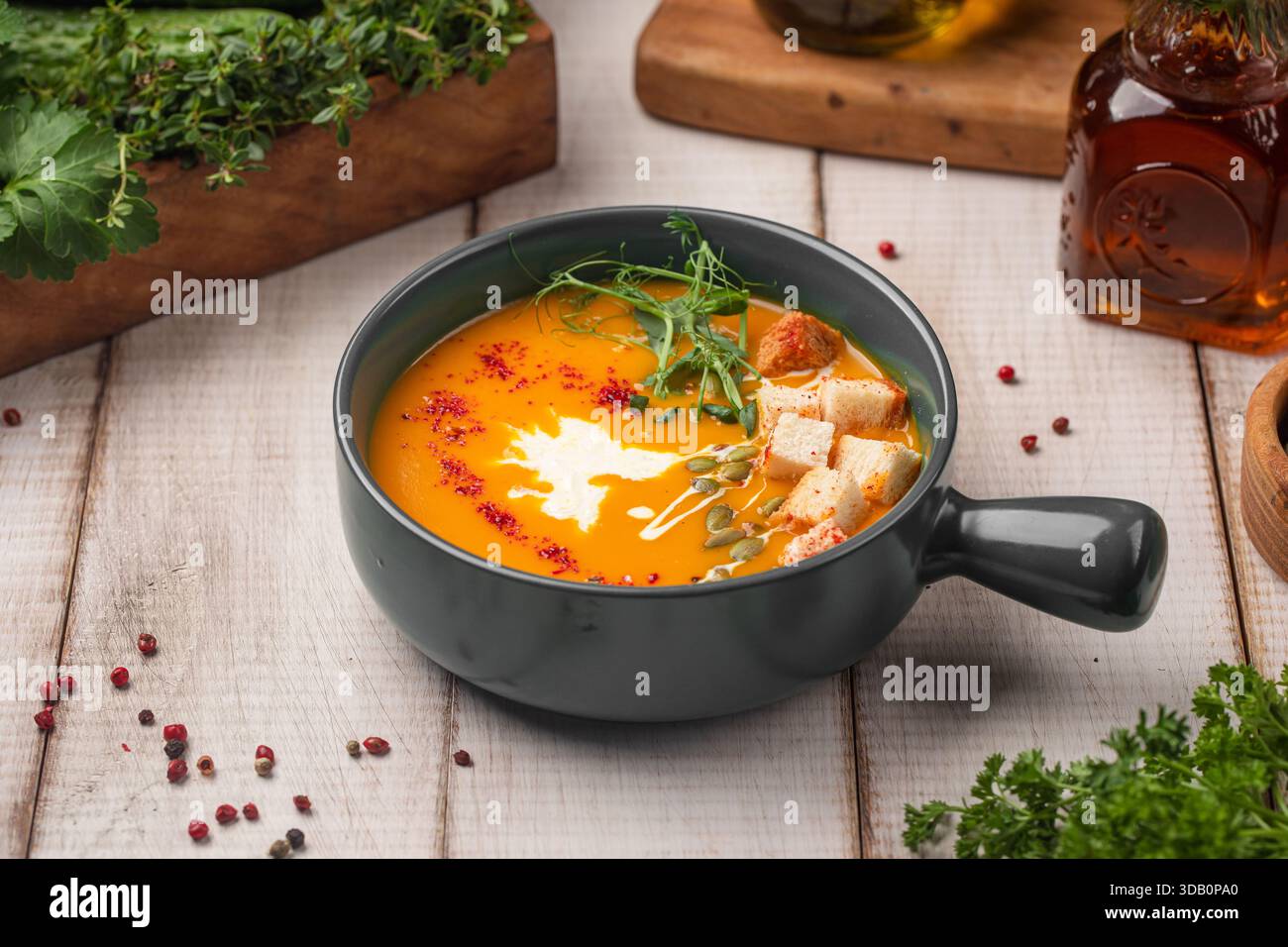 Creamy pumpkin soup with herbs and croutons Stock Photo