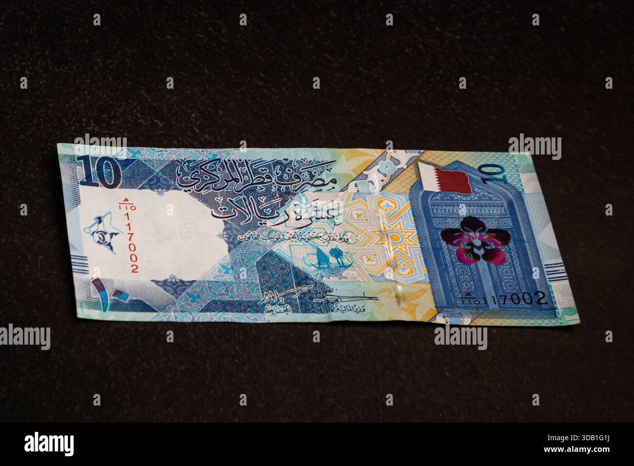 Qatari riyal banknotes on dark background showing national symbols ...