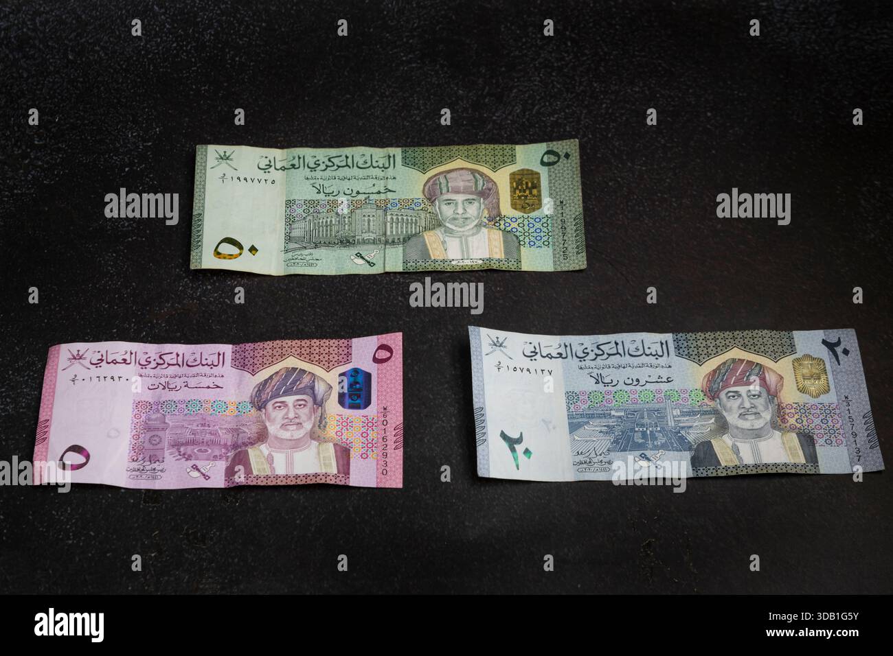 Omani rial banknotes denominations arranged on dark background, showing ...