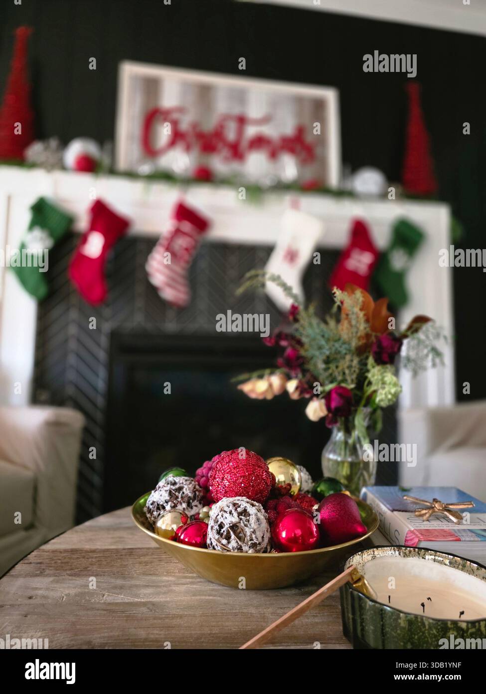 Decorative Christmas setting with ornaments and stockings displayed on a fireplace in a cozy room - Smartphone Captured Stock Image