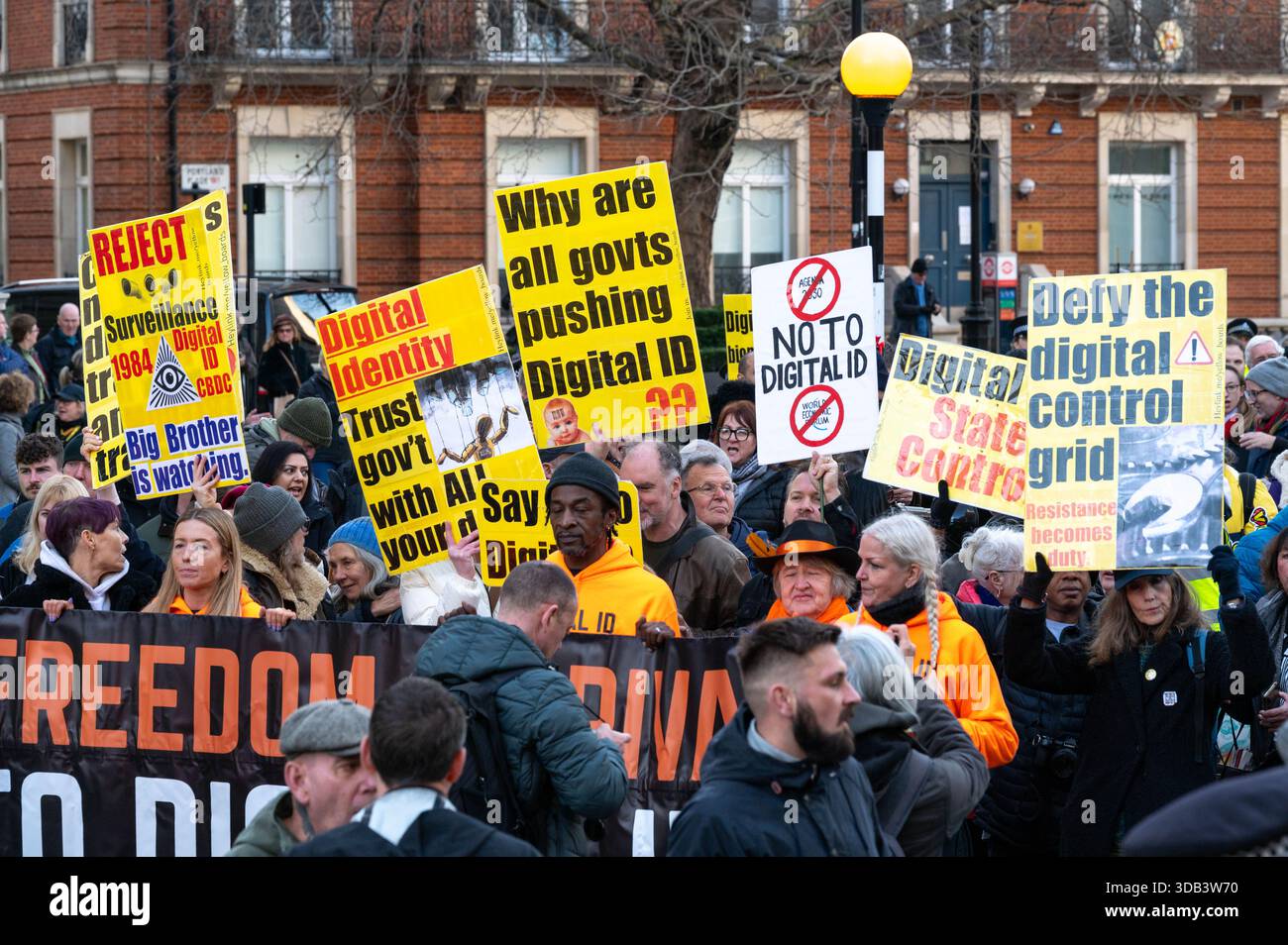 Protesters march with placards and a banner saying 