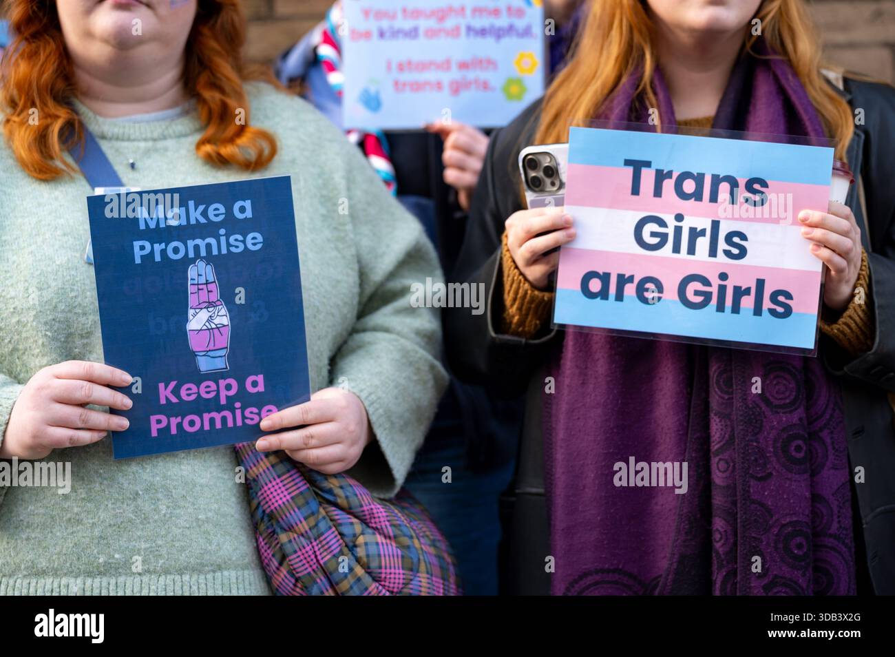 Protesters hold placards saying 