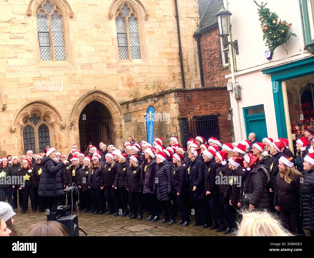 Lincoln Cathedral and street scene people singing in the rock Choir with Christmas hats happy Cultural tourism cityscape heritage site architectural - Smartphone Captured Stock Image