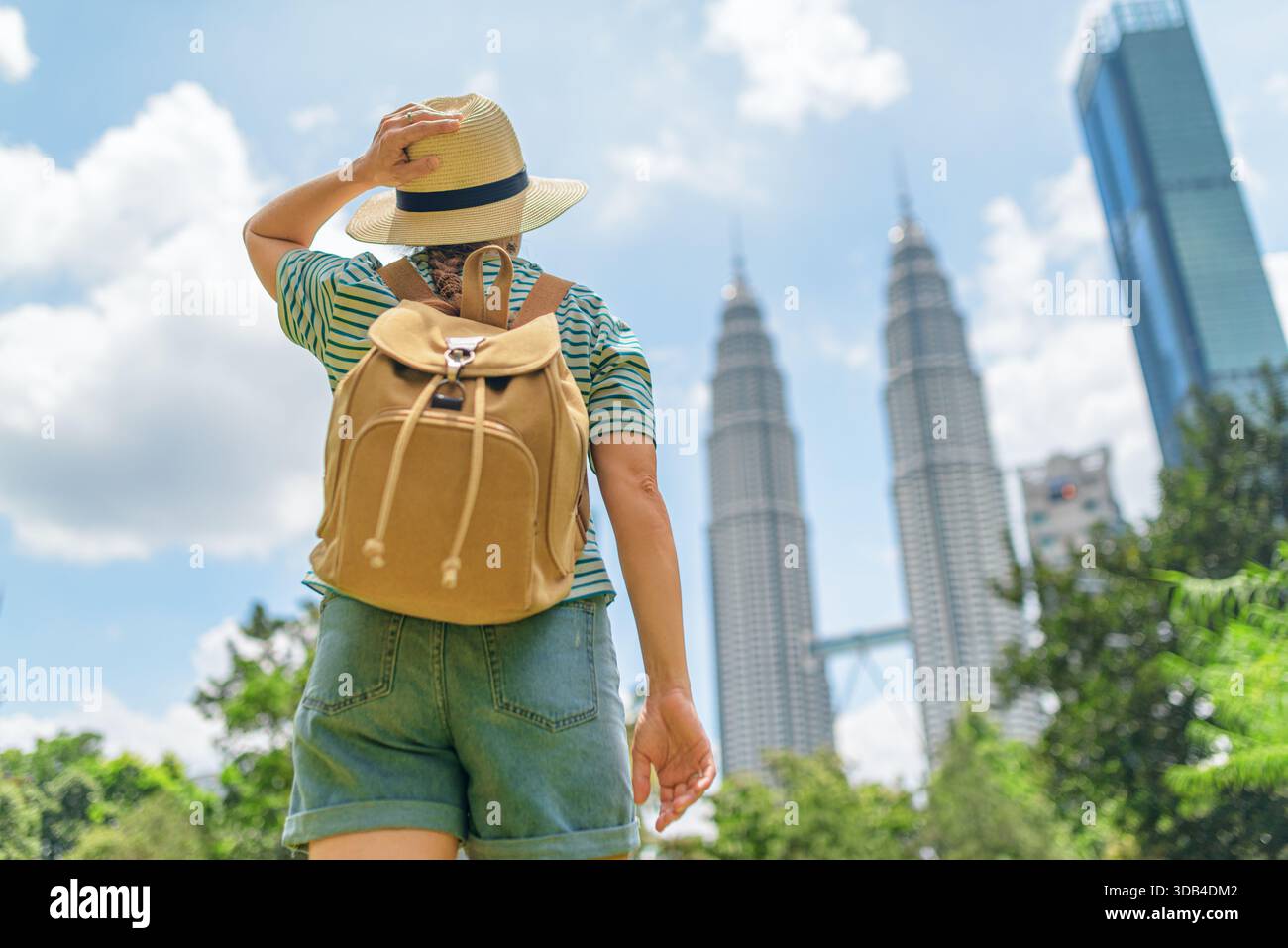 backpack malaysia travel Female tourist in hat with backpack enjoying cityscape, Malaysia Stock  Photo