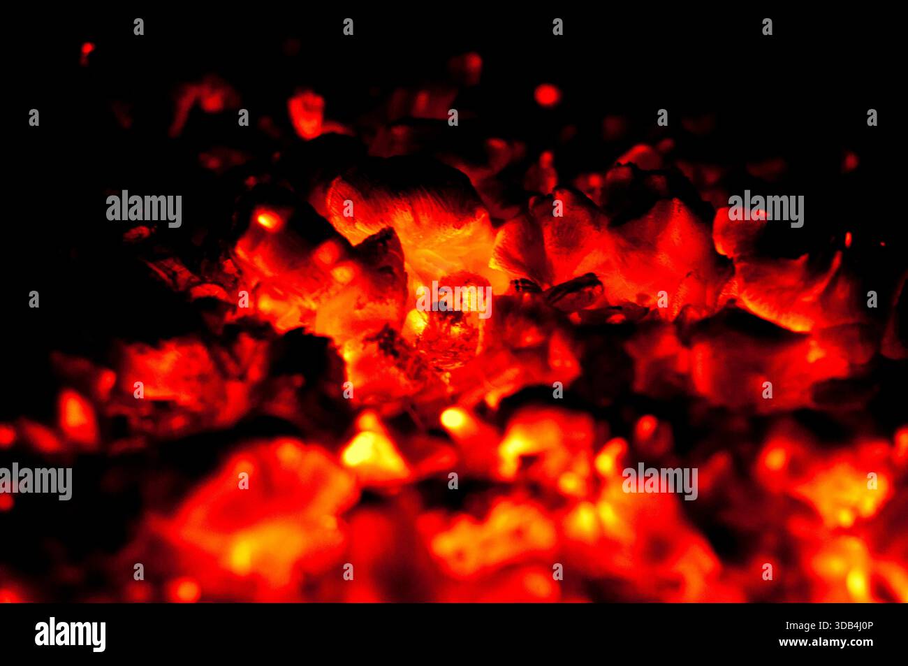Glowing hot coals with fire texture in dark background Stock Photo