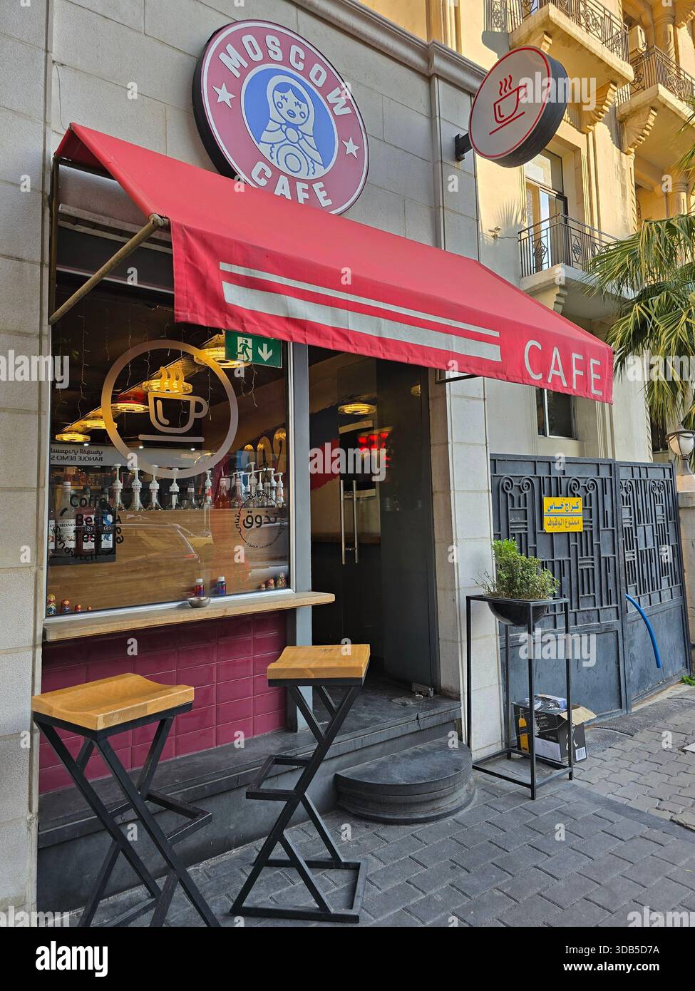 "Exterior of a small modern coffee shop in Damascus, Syria, featuring stylish outdoor seating and cozy urban ambiance." - Smartphone Captured Stock Image
