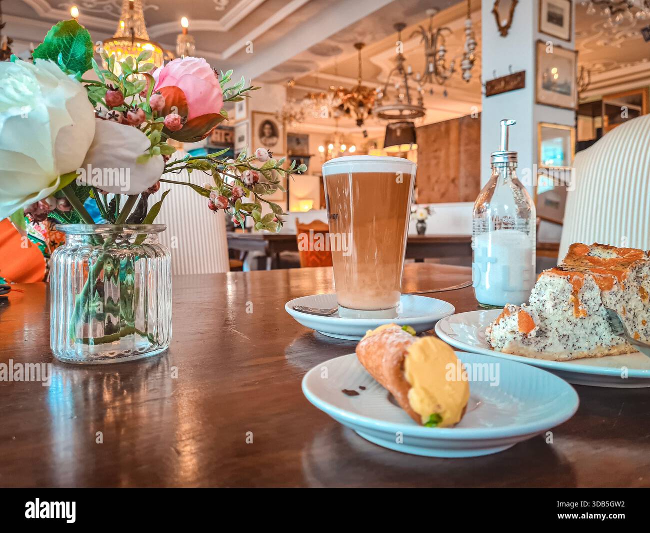 Latte Macchiato and Gourmet Desserts on a Wooden Table in an Elegant Vintage European Cafe Interior Stock Photo