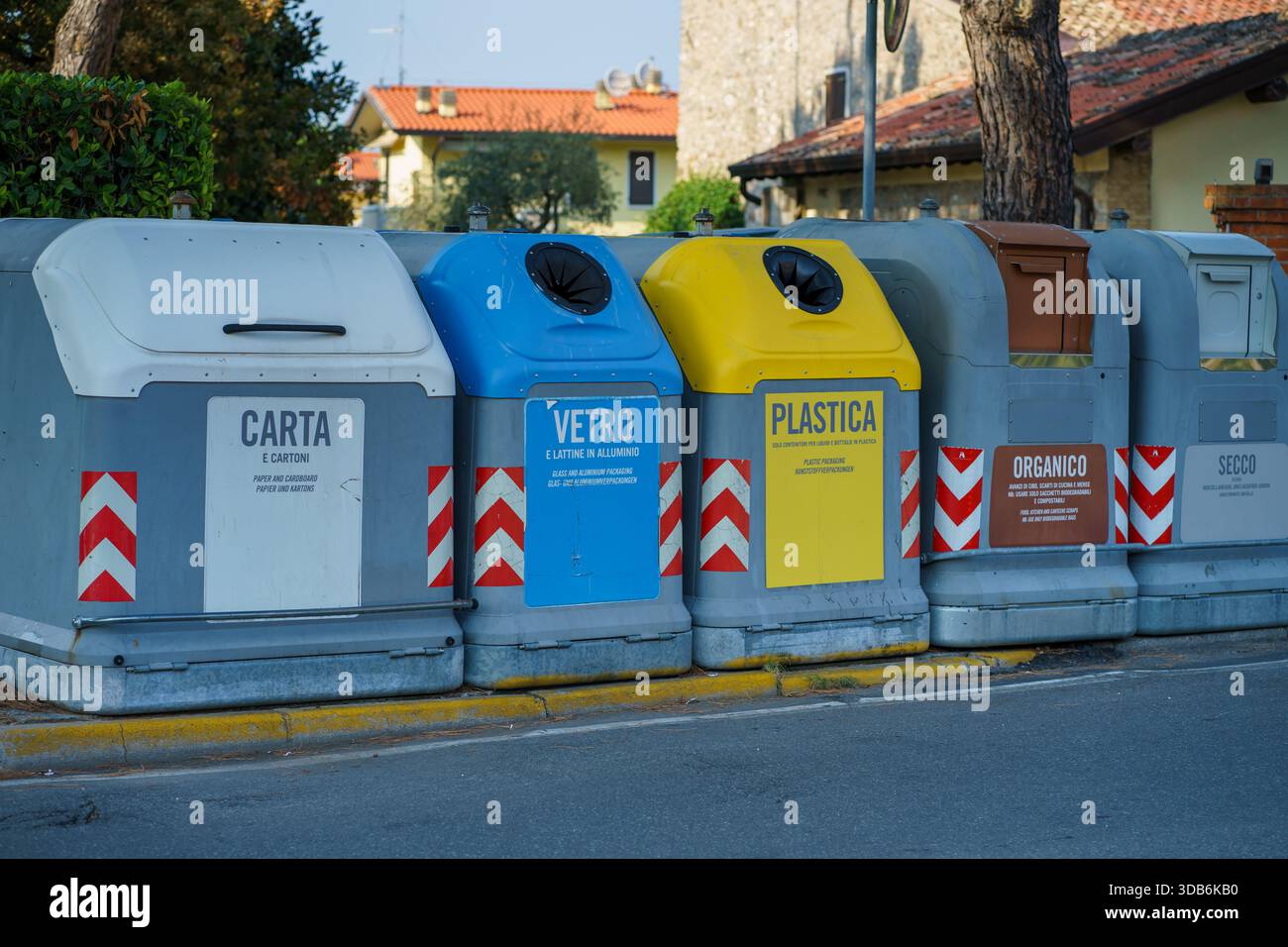 Row of color coded recycling containers for paper, glass, plastic ...