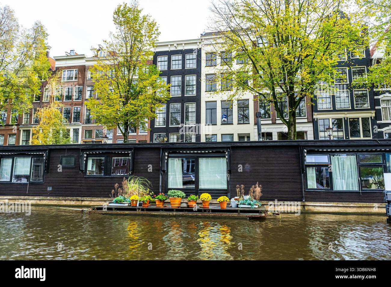 A floating house in Amsterdam canal. Boat home on water. Houseboat in ...