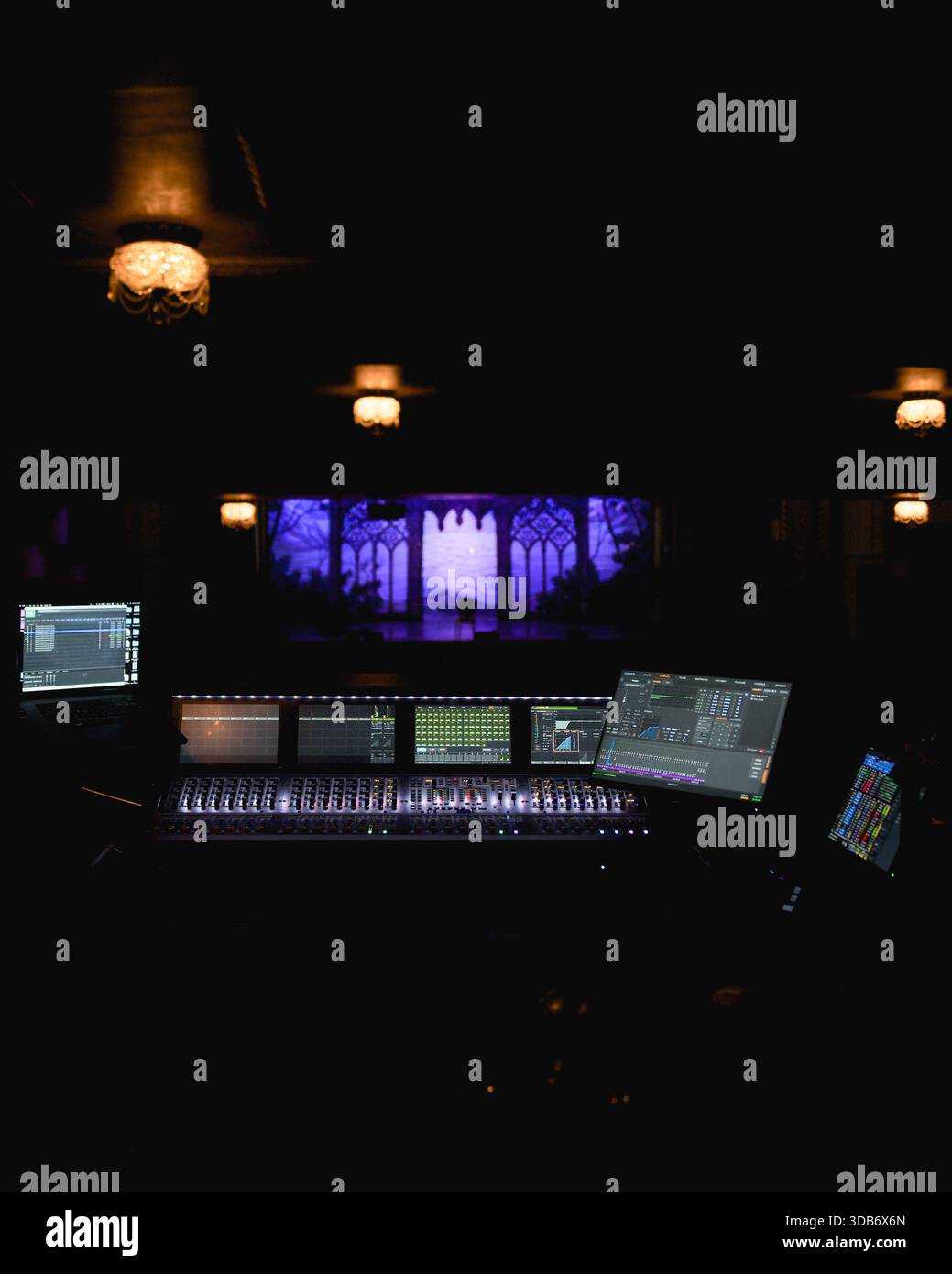 Digital audio mixing console with illuminated screens at live concert ...