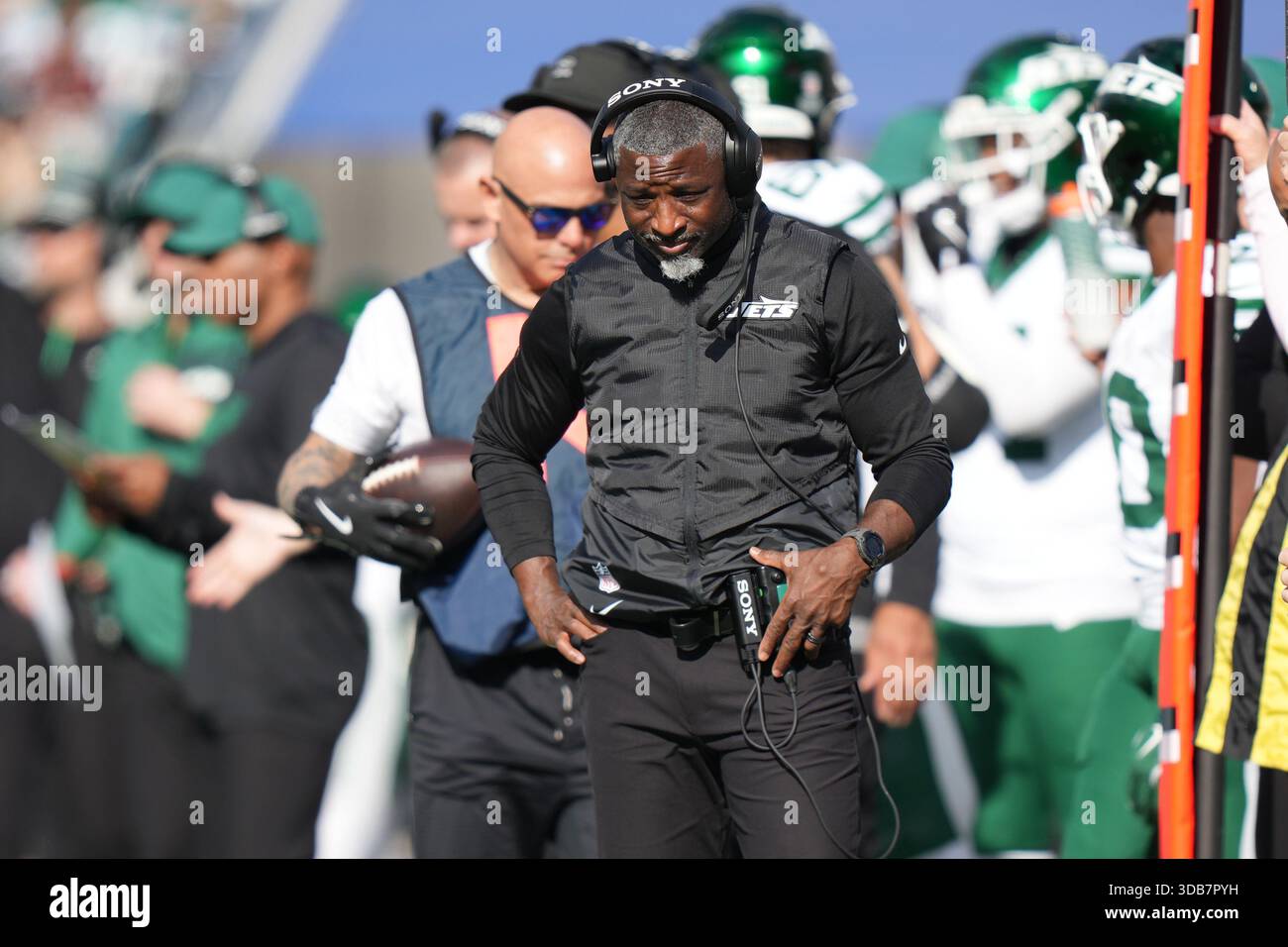 New York Jets head coach Aaron Glenn listens to his headset during an ...