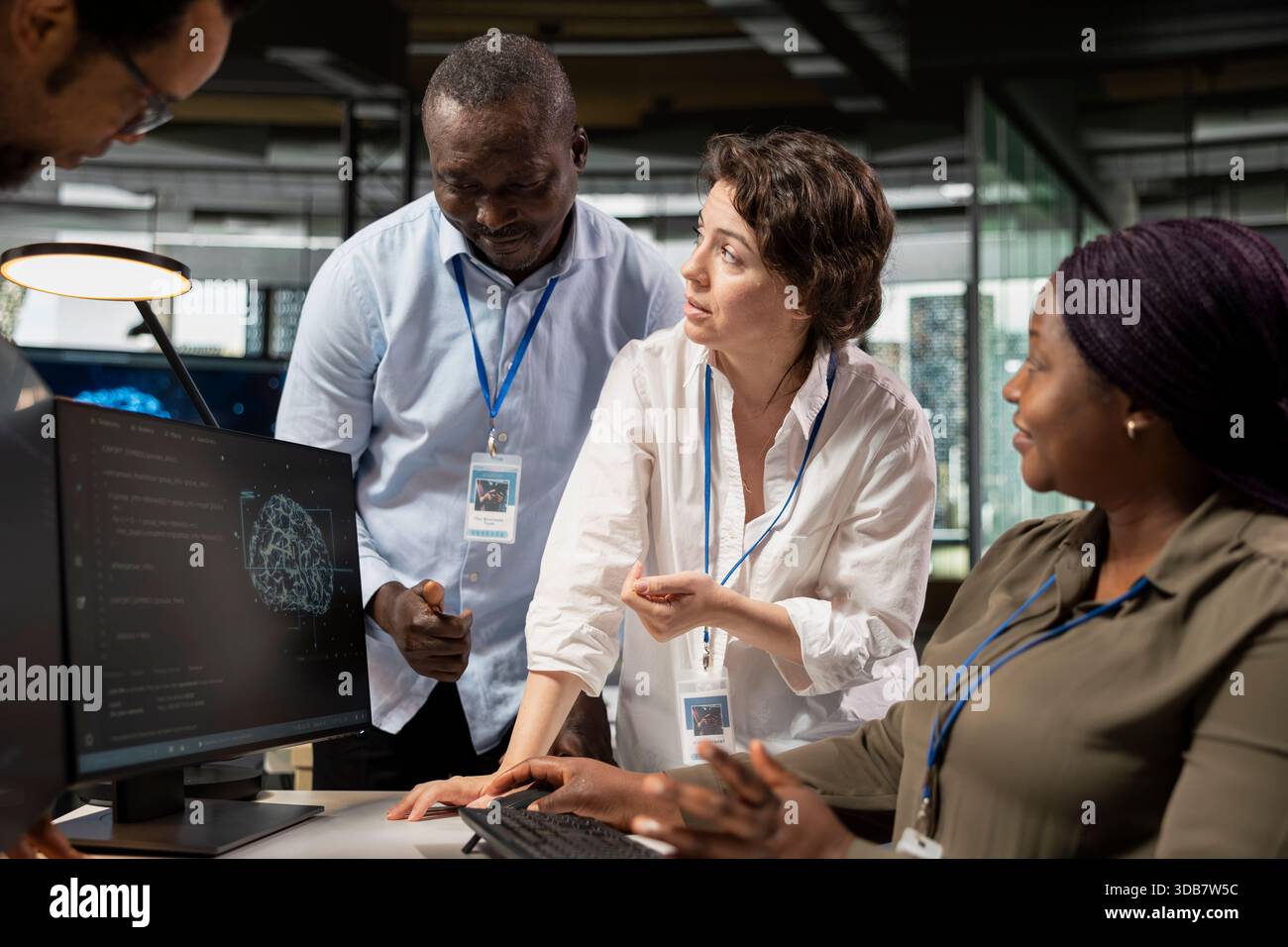 Engineering team working together, running AI algorithms on PC in startup workspace. Teamworking colleagues using artificial intelligence deep learning coding platform on computer Stock Photo