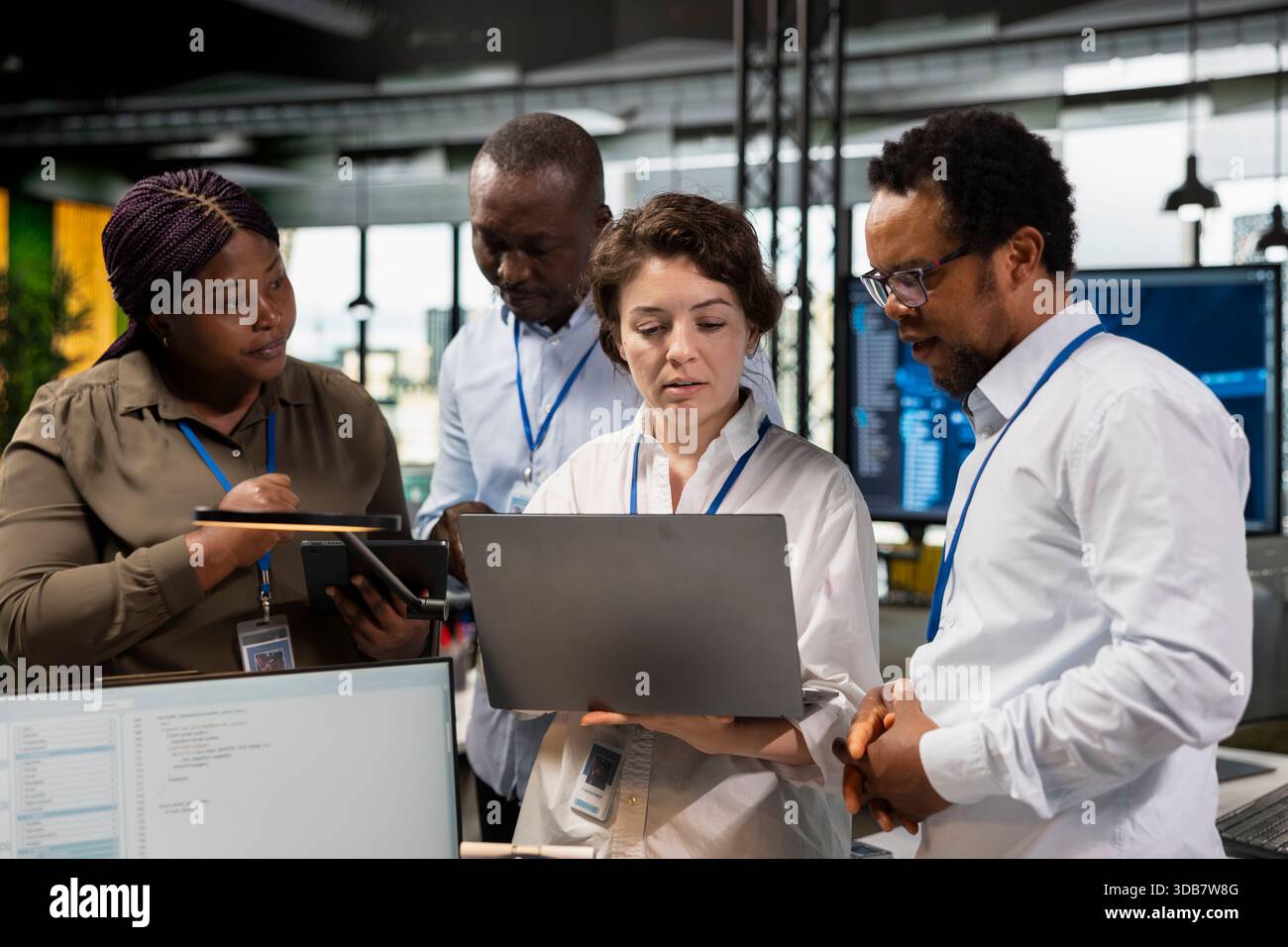 Teamworking programmers brainstorming ways to develop applications in startup office, looking at laptop screen. Engineers optimizing performance by debugging application code to resolve issues Stock Photo