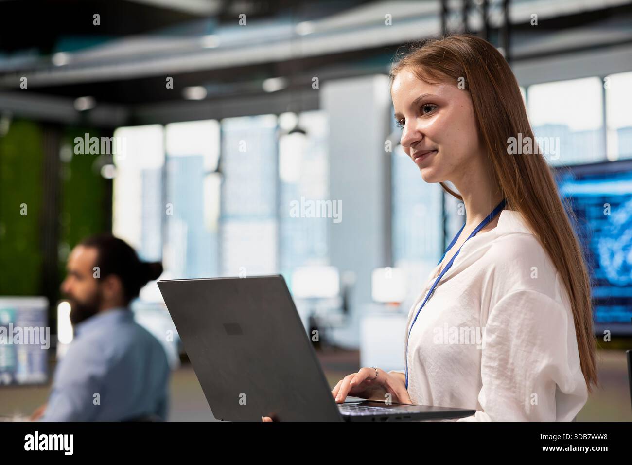Joyful female engineer adjusting deep learning algorithms parameters on laptop to automate tasks. Tech company intern working with AI driven insights on notebook for code optimization Stock Photo