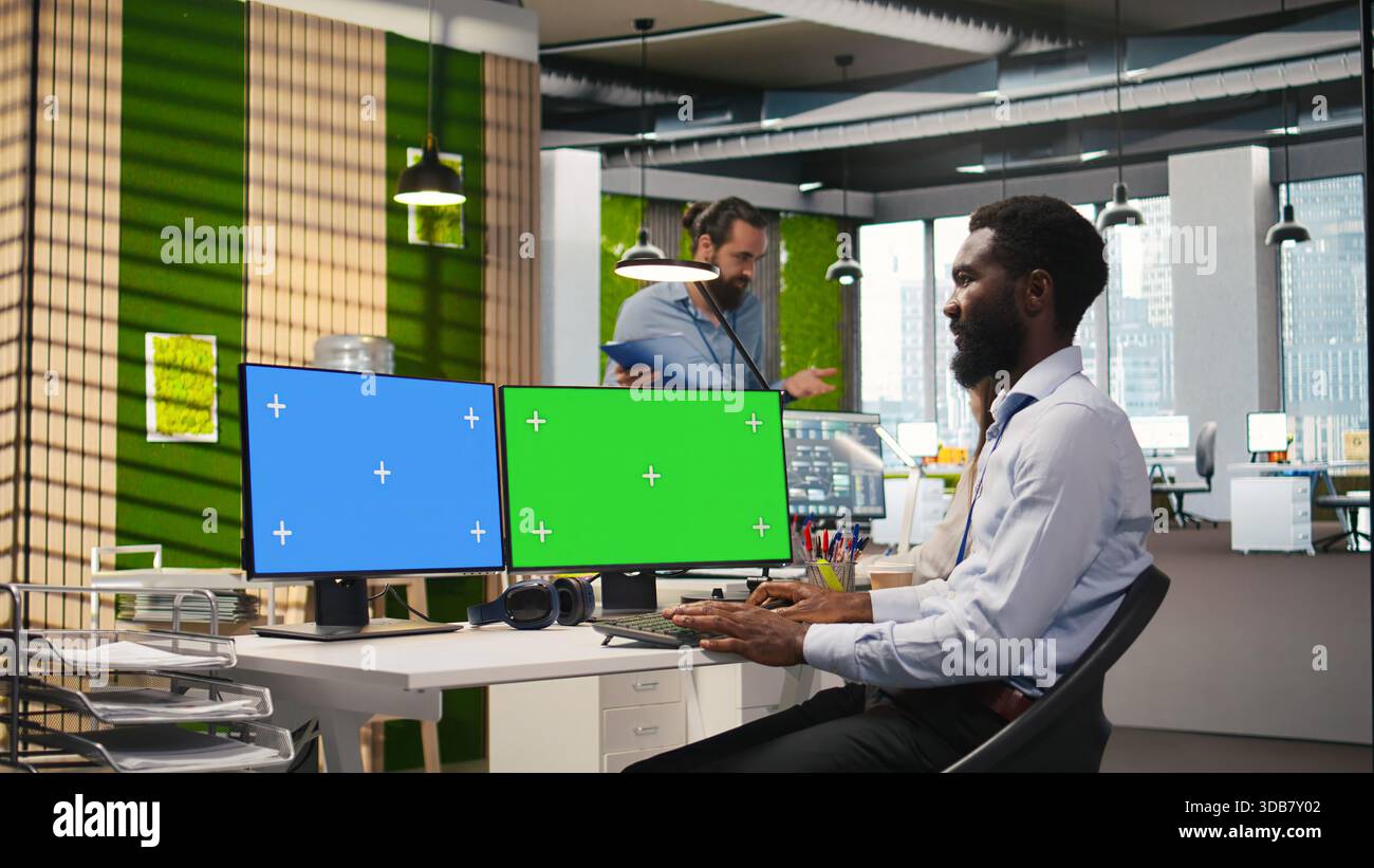 Technician using green screen PC to code AI algorithms debugging software issues and improving system stability. IT specialist in tech startup office using mockup computer, camera A Stock Photo