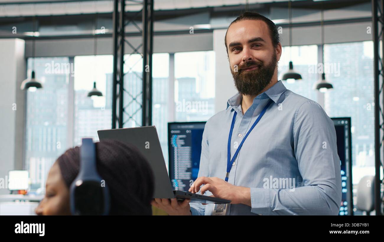 System administrator in office developing software applications, integrating AI driven automation in operations. IT expert using laptop, debugging applications to resolve issues, camera A Stock Photo