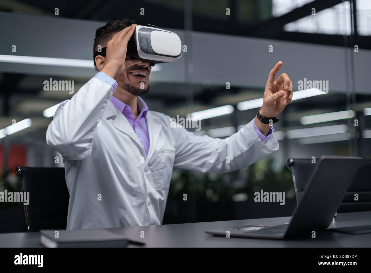 Man Using Virtual Reality Headset in Office Setting During Work Hours Stock Photo