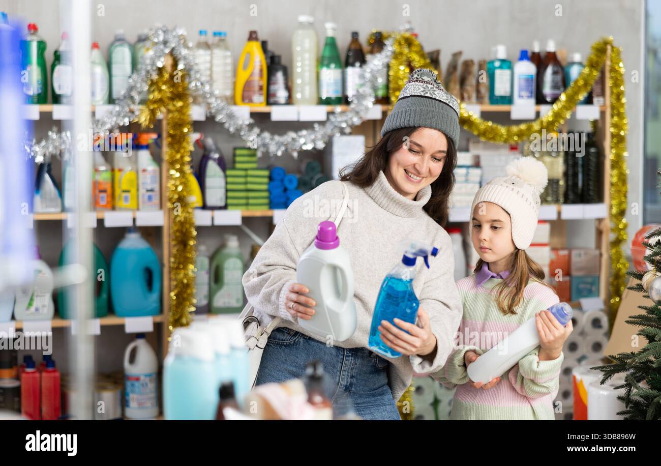 Mother and daughter choose for window cleaning spray and detergent ...