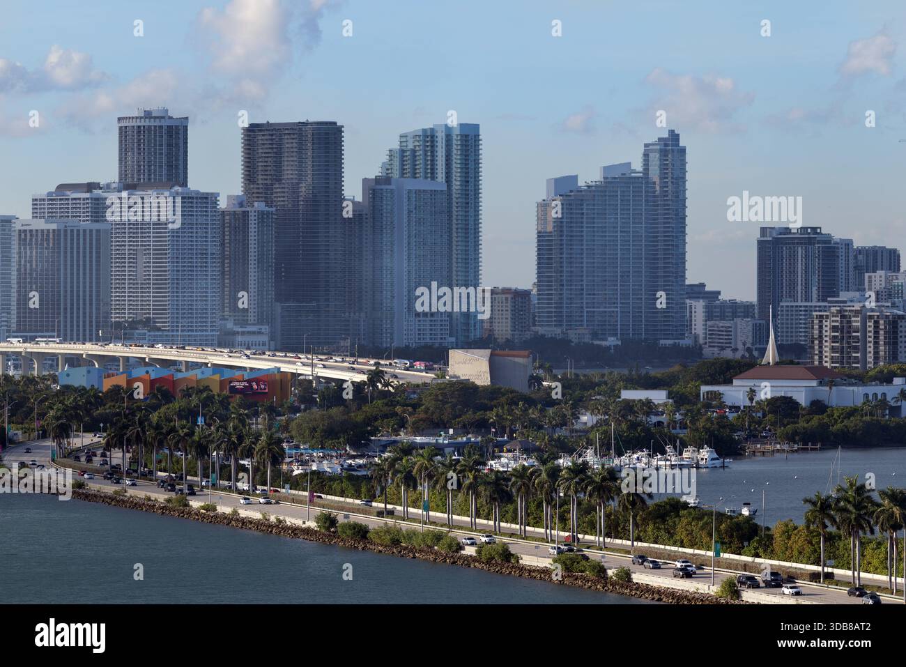 The Miami skyline rises beyond Biscayne Bay, with palm-lined causeways ...