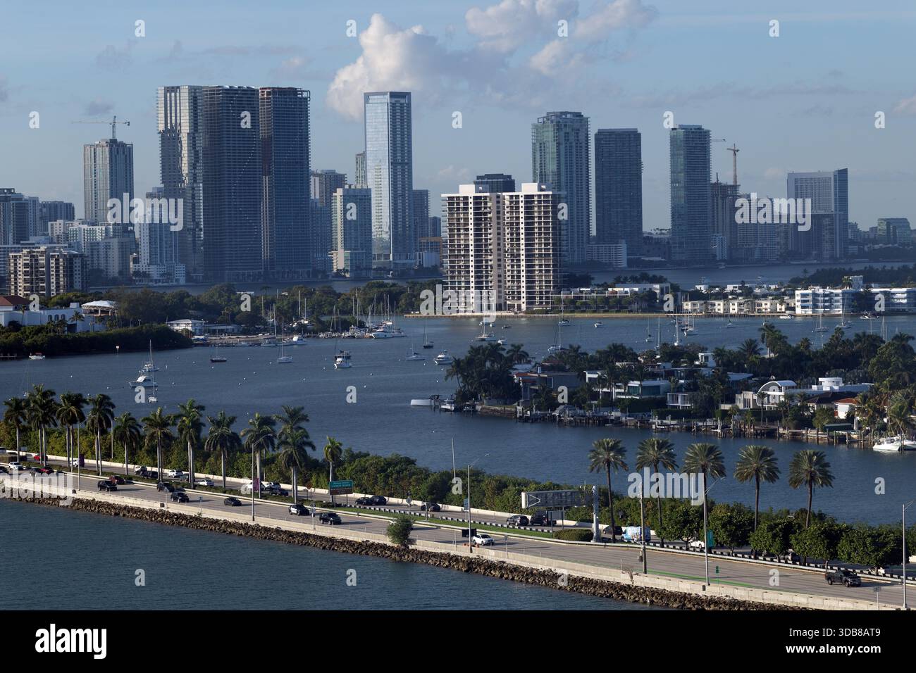The Miami skyline rises beyond Biscayne Bay, with palm-lined causeways ...