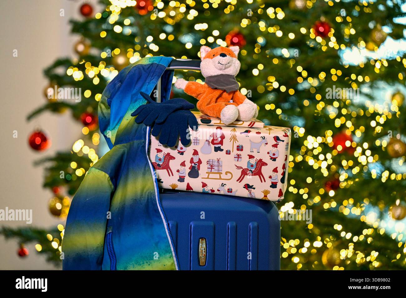 Kinderjacke, Handschuhe, Stofftier und Geschenke liegen auf einem gepackten  Rollkoffer, im Hintergrund ein geschmückter Weihnachtsbaum Themenbild vom  11.12.2025. Laut Bertelsmann-Stiftung waechst jedes sechste Kind in  Deutschland mit getrennten Eltern ..., image size:1300x956