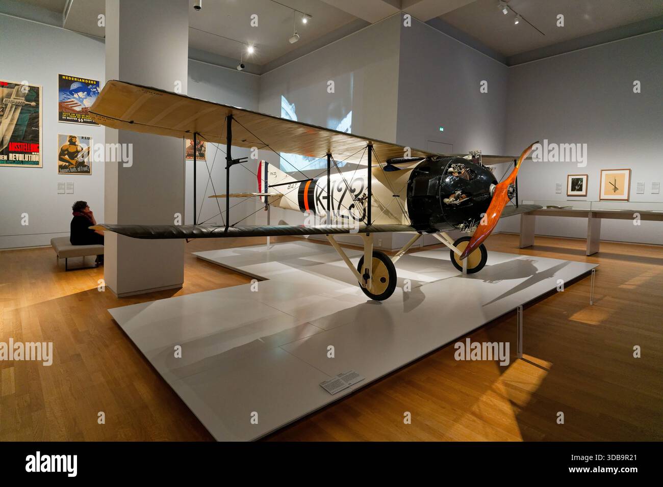 A vintage biplane is prominently exhibited in a museum gallery ...