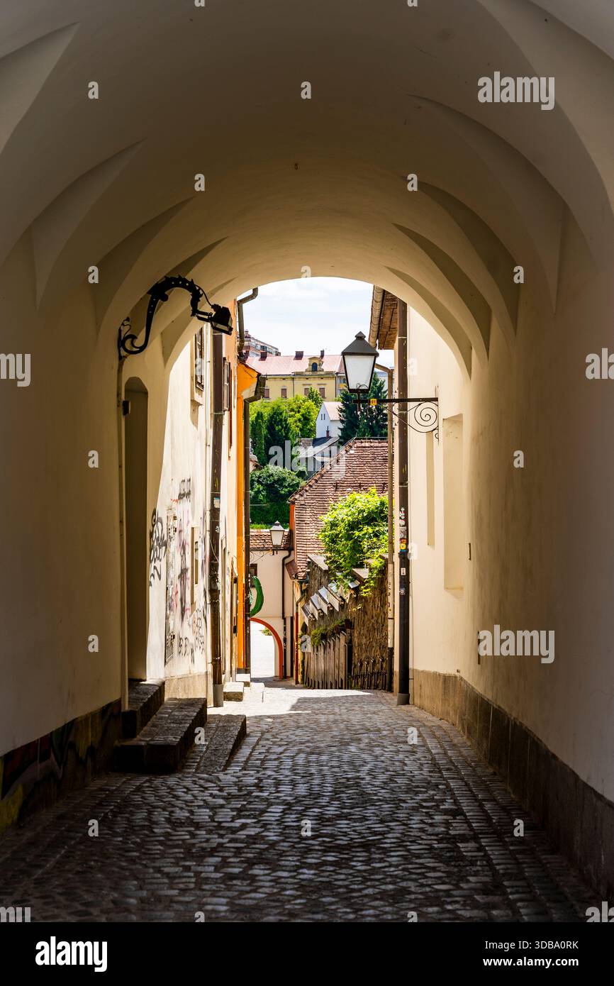 Picturesque covered passage leading from Glavni Trg into a quiet residential alley, revealing the charming atmosphere of central Maribor, Slovenia Stock Photo