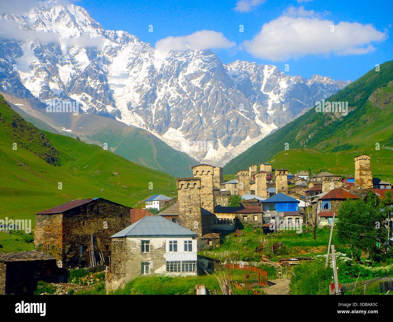 Scenic view of the medieval stone towers in Ushguli village, Svaneti region, Georgia, with the snow-capped peak of Mount Shkhara in the background. - Stock Image