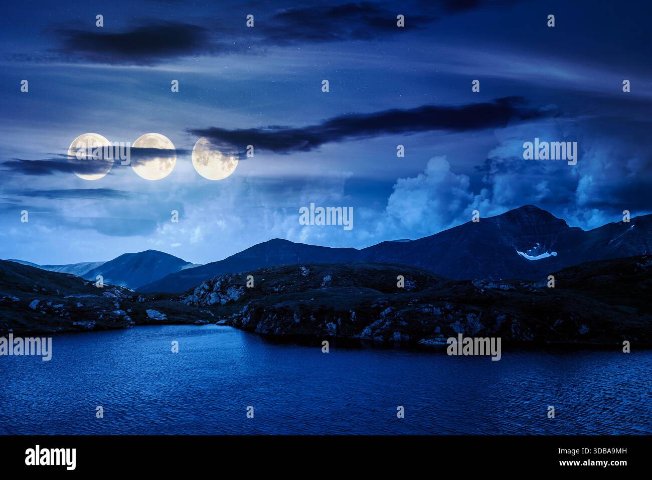 serene alpine lake among green hills at night. beautiful summer landscape with gorgeous sky over mountain peaks in three full moon light. finance bubb Stock Photo