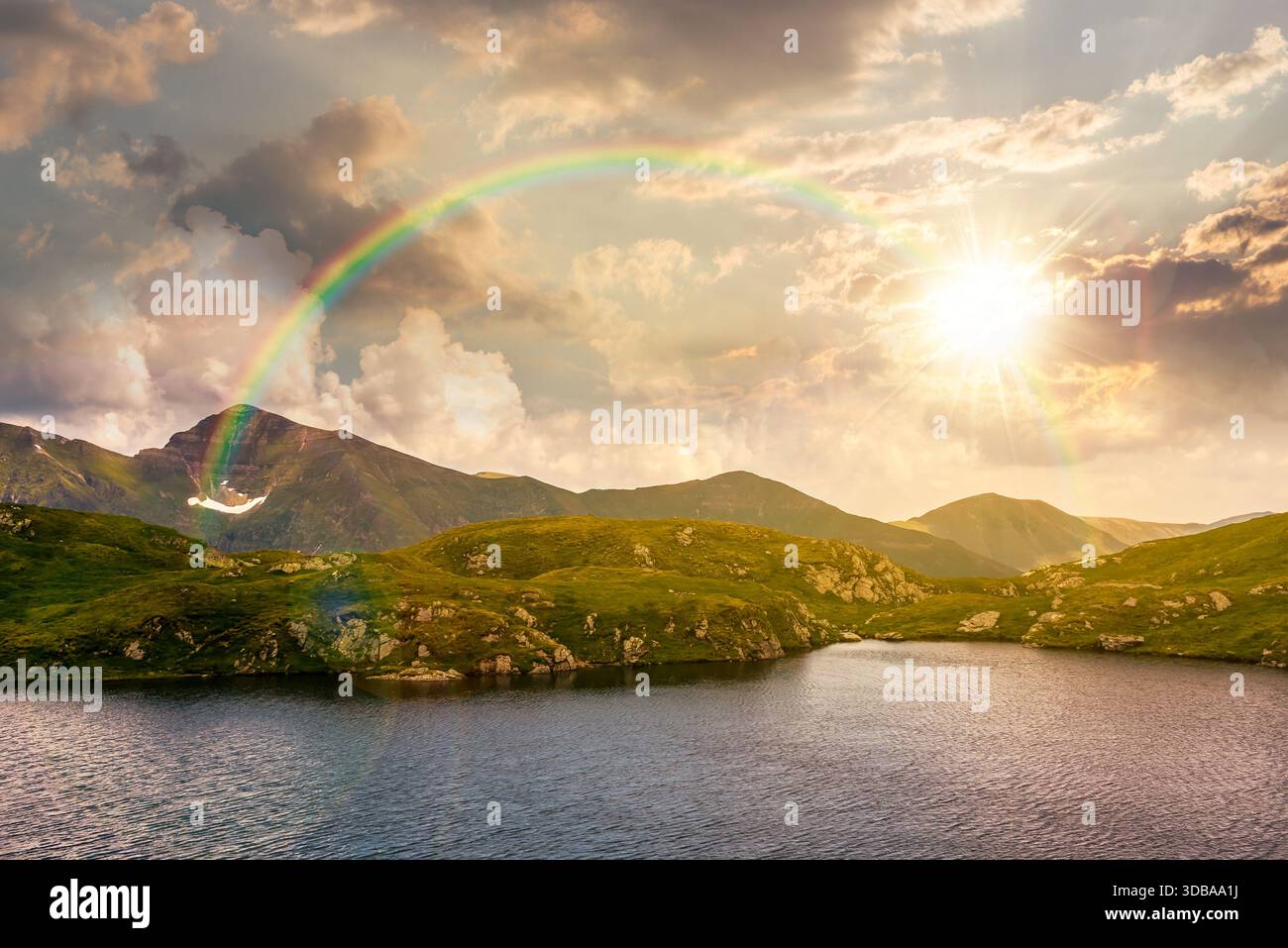 serene alpine lake among green hills at sunset. beautiful summer landscape with gorgeous sky over mountain peaks in evening light. storytelling cinema Stock Photo