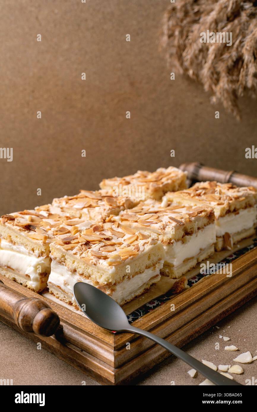 Homemade Norwegian sweet cake Verdens Beste Kake with custard, meringue,  and almonds, cut into squares, served on wooden tray. Beige table, close-up  Stock Photo - Alamy, image size:866x1390
