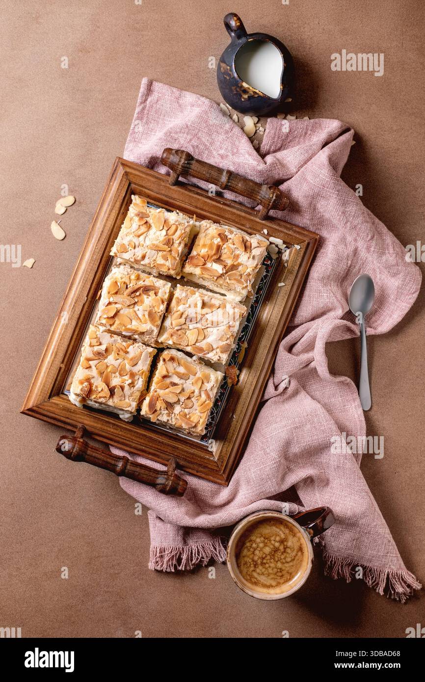 Homemade Norwegian sweet cake Verdens Beste Kake with custard, meringue,  and almonds, cut into squares, served on wooden tray. Beige background,  pink Stock Photo - Alamy, image size:866x1390