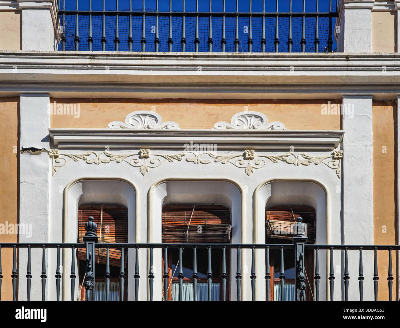 Detail of a balcony in Seville shows plasterwork, iron railings, and ...