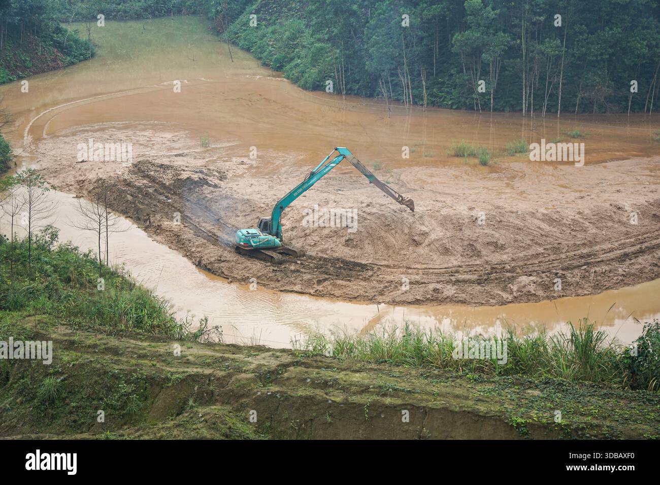 Excavator working in muddy terrain, construction site in a forest Stock ...