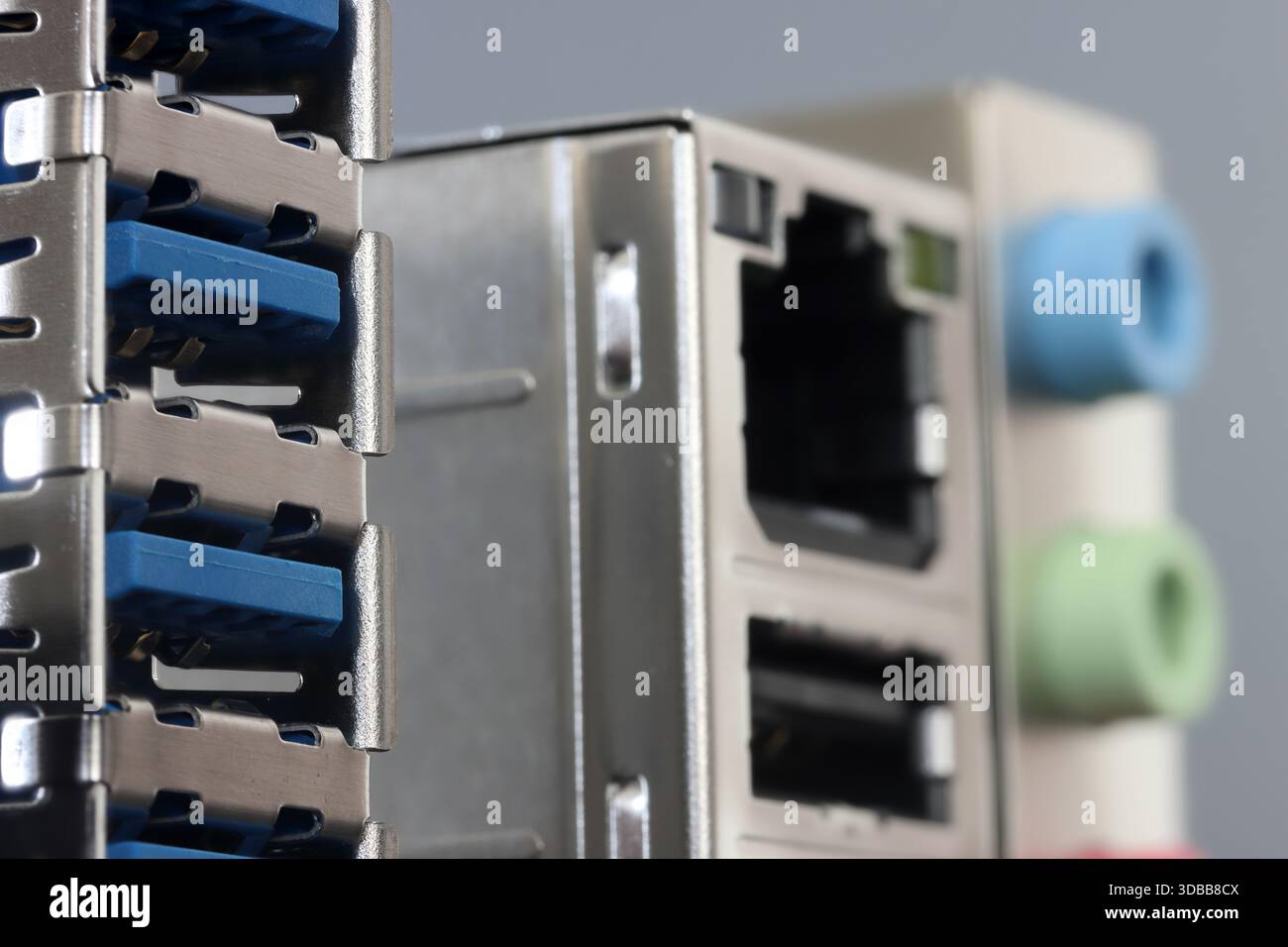 Close-up of a metal back panel featuring stacked USB ports, RJ 45, and color audio jacks Stock Photo
