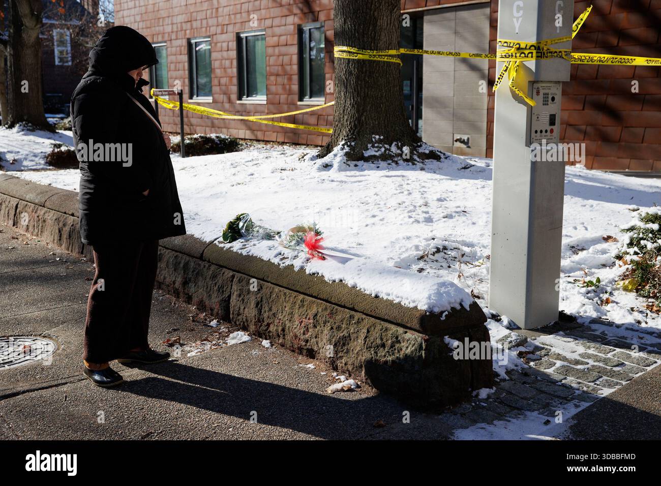 Providence, United States. 15th Dec, 2025. A woman stops to pay her ...