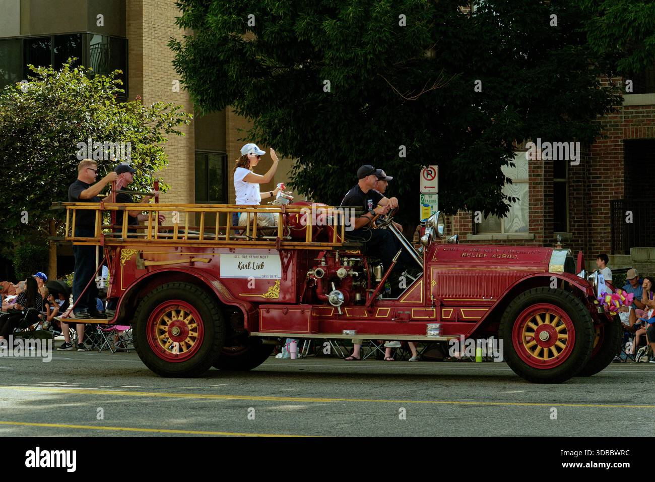 Parade Fire Engine Historic fire truck drives through parade with people and spectators in ...