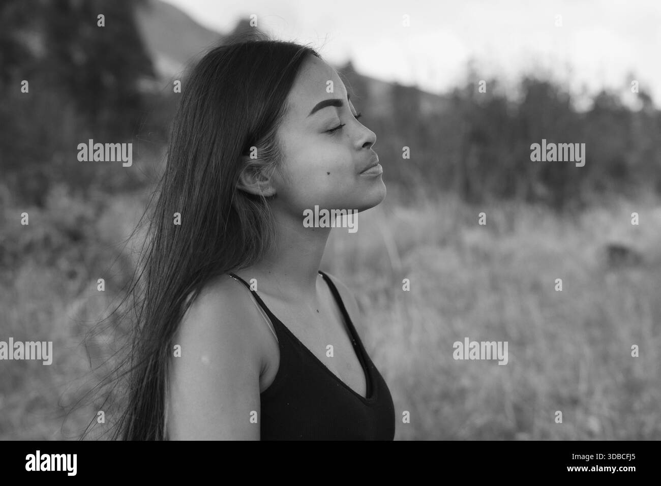 Black and white portrait of a serene young woman enjoying the ...