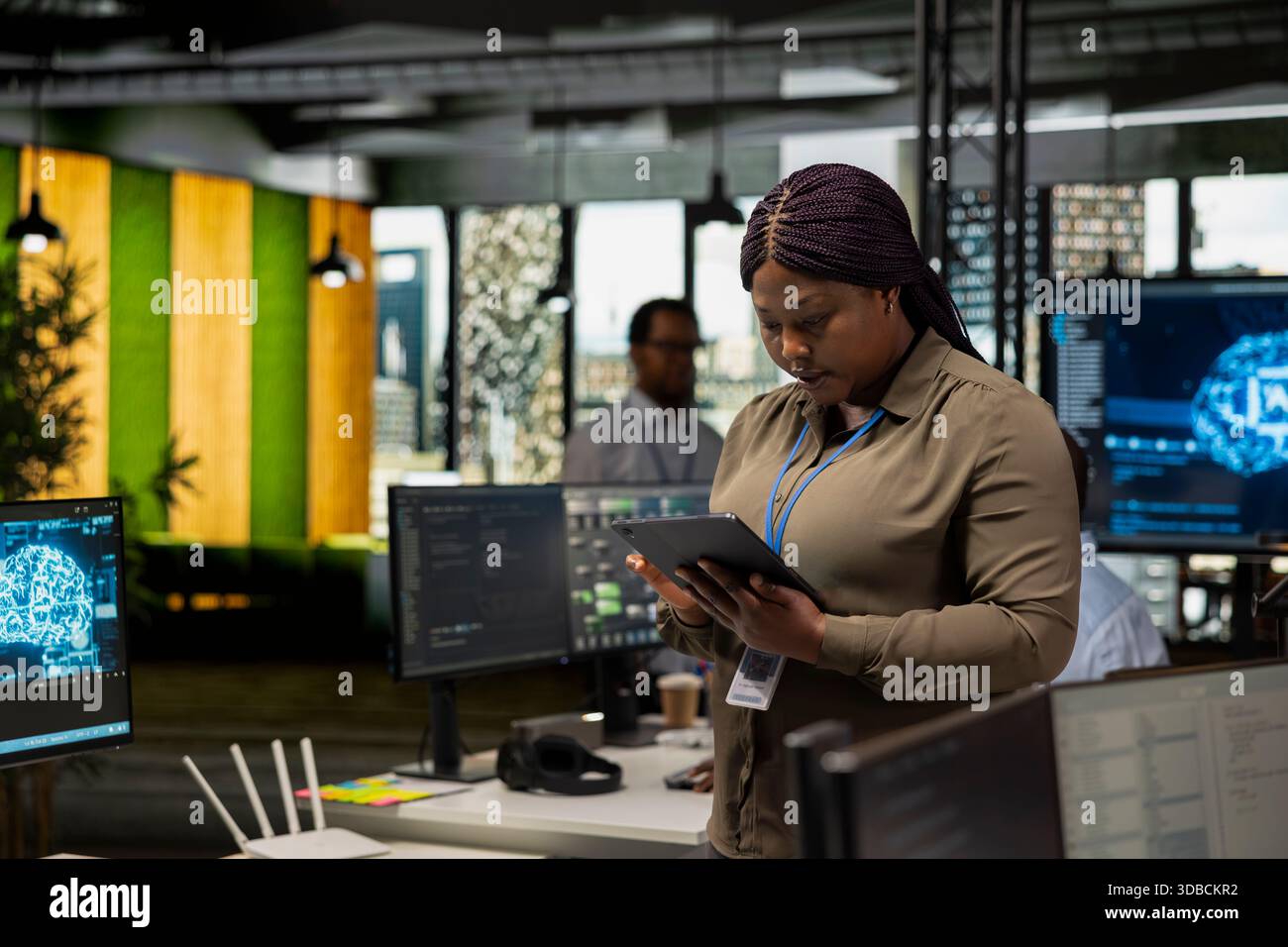 Programmer in office automating repetitive tasks using AI scripts on tablet. IT professional using artificial intelligence technology on device to speed up feature implementation Stock Photo
