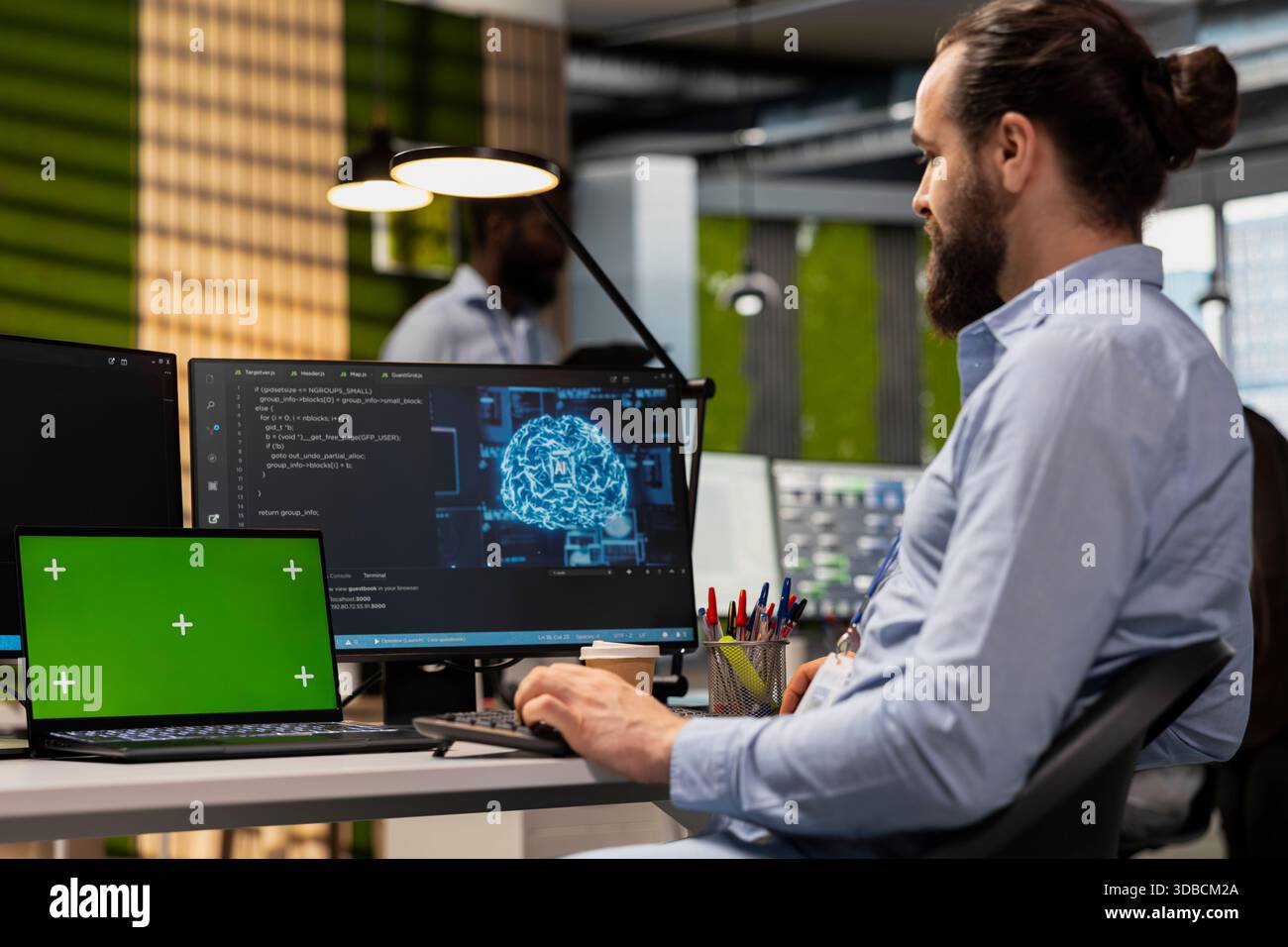 Technician using green screen tablet to code AI algorithms debugging software issues in tech startup office. Man at work using chroma key device, improving system stability Stock Photo