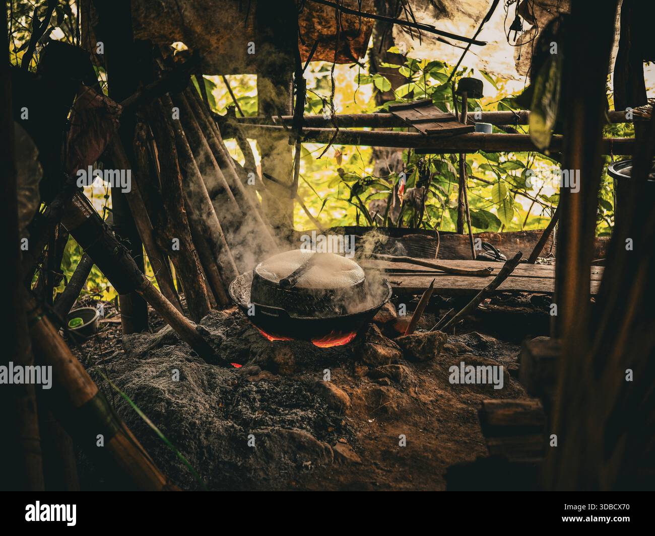 Traditional palm sugar making process using firewood, cooking palm sap in a rustic outdoor kitchen with traditional equipment and no people visible. Stock Photo