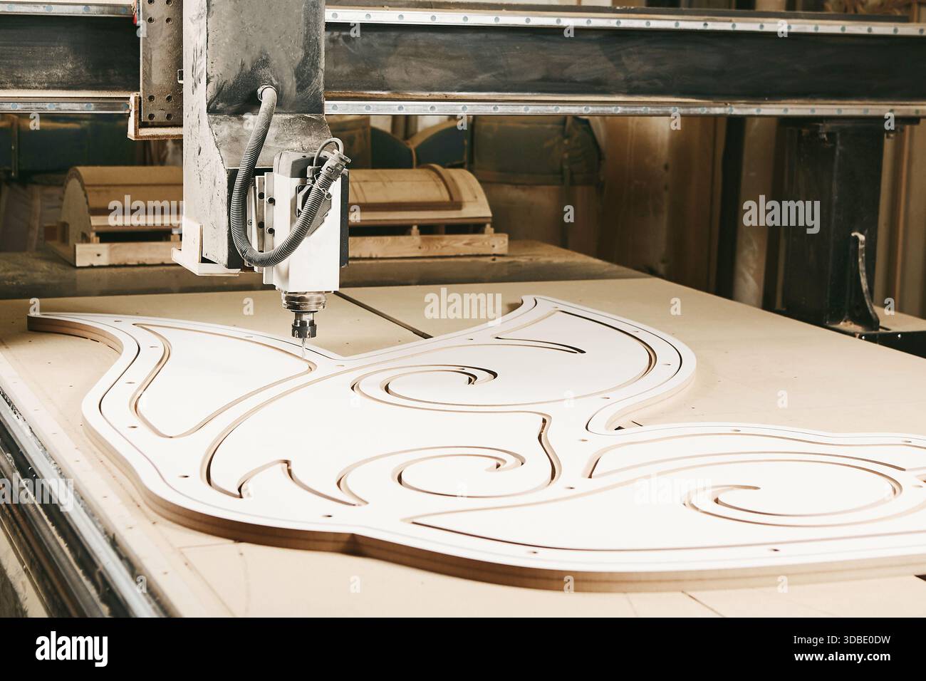 Numerically controlled woodworking machine cuts rounded complex lines on the canvas. Computer numerical control. CNC. Stock Photo