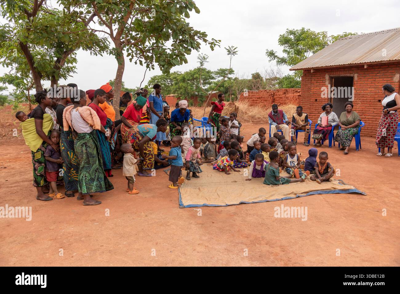 Mawero Lilongwe Malawi Africa.10.11.2025.  Malawian school children and parents singing and clapping to welcome guests to this rural school and church - Stock Image