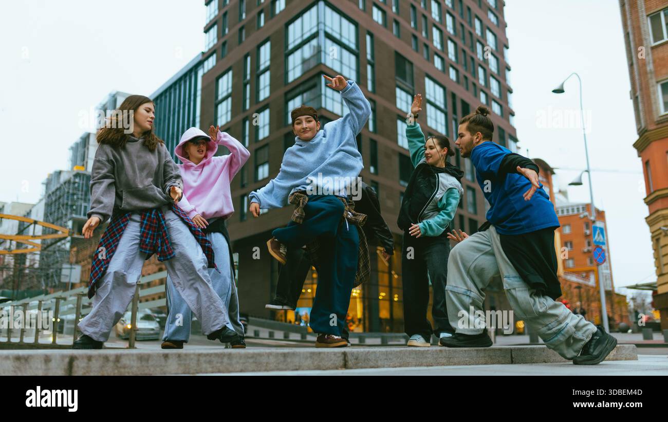 Hip hop dancers practicing freestyle routine on modern city square. Stock Photo