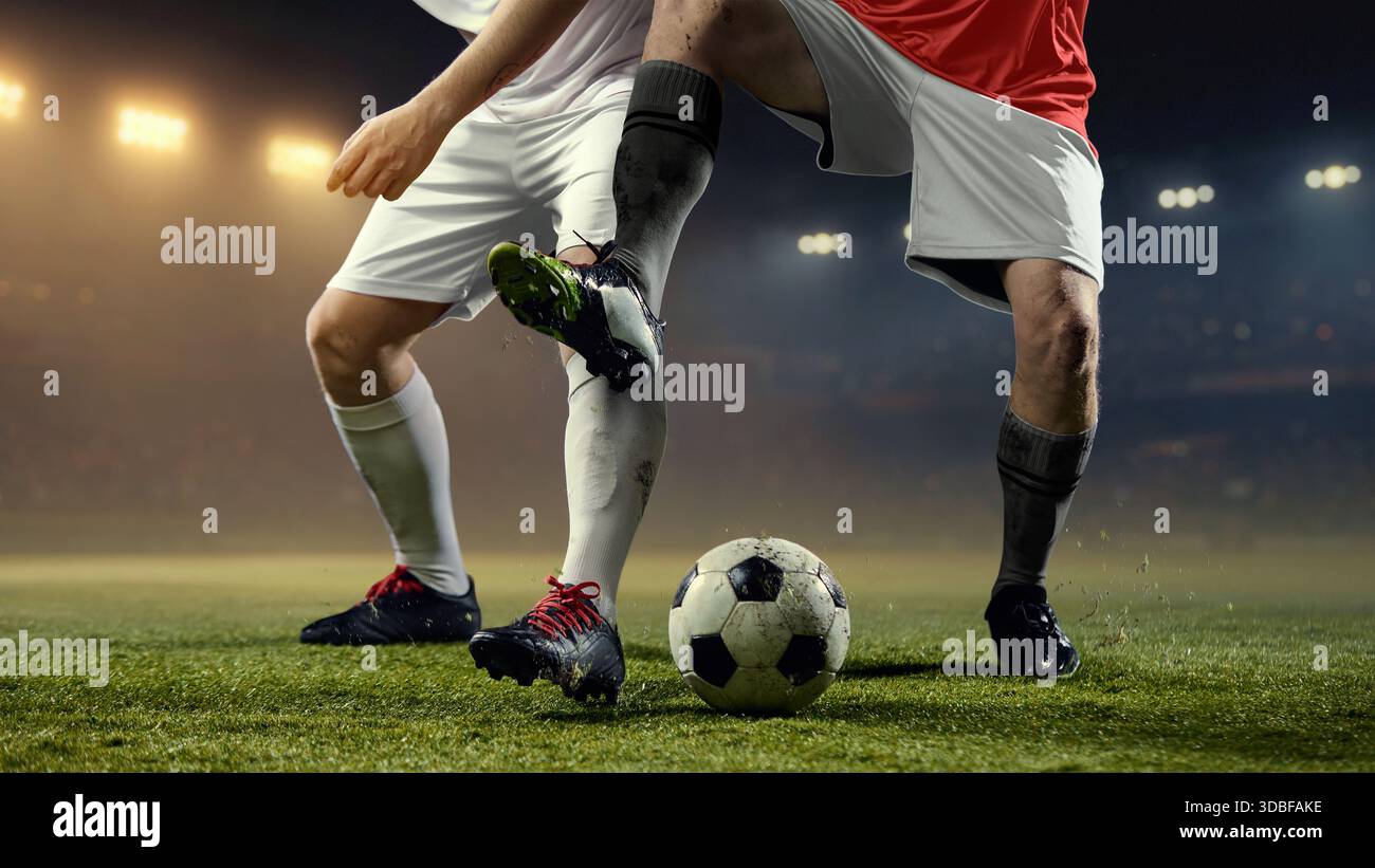 Fast paced football action with two players legs battling for ball on ...